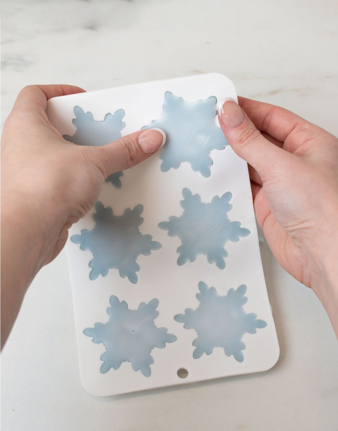 Removing beeswax Christmas ornaments from silicone molds.