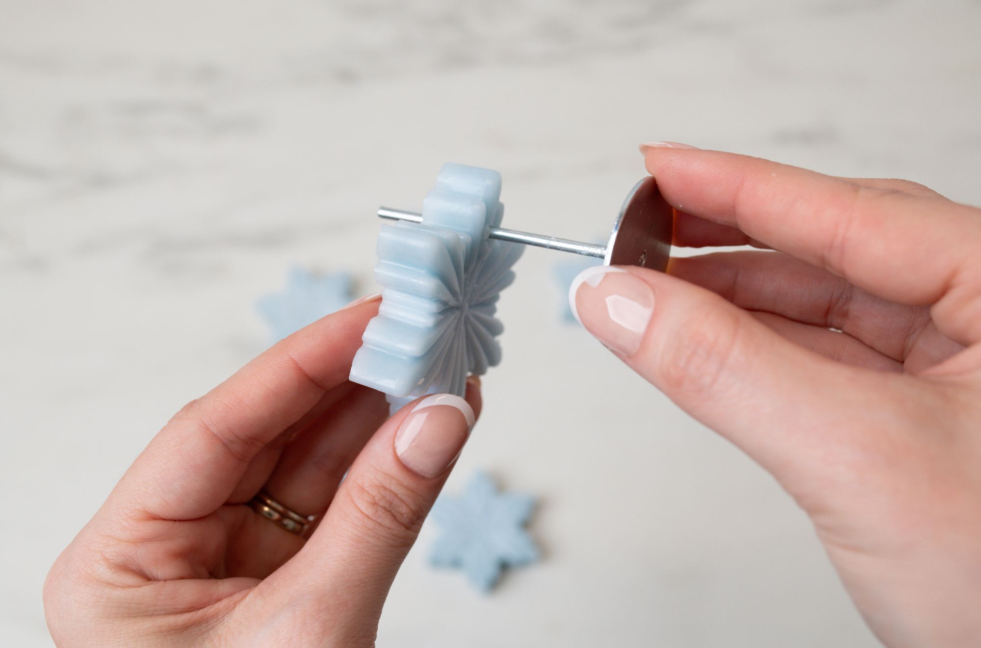 Poking wick pin through wax ornament