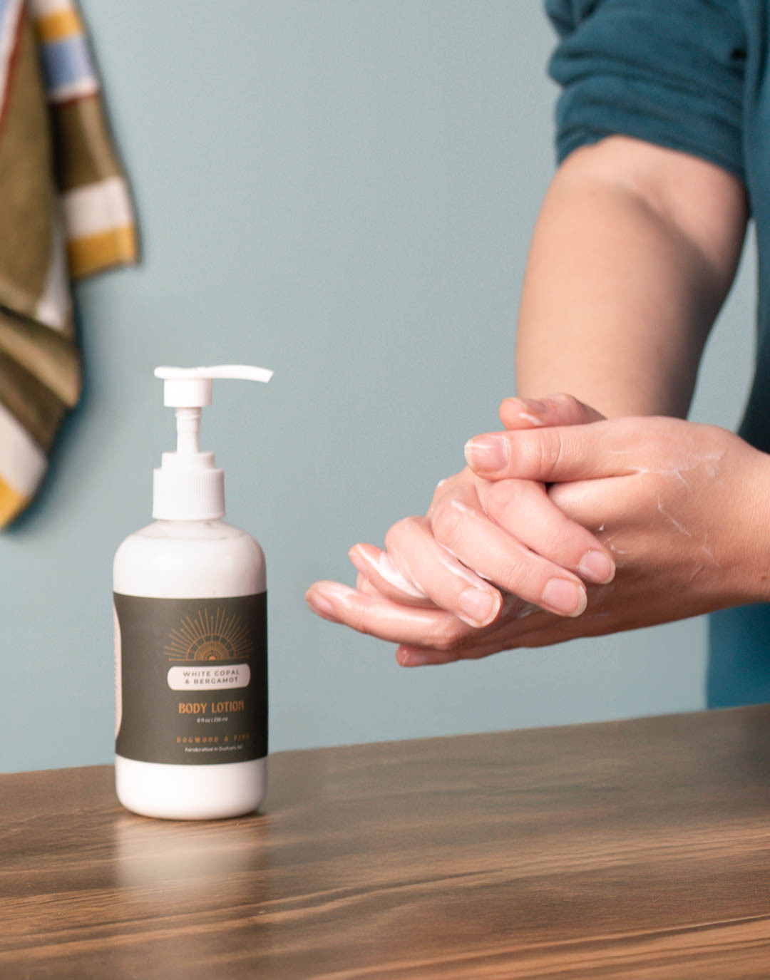 A pair of light-skinned hands applying lotion made with CandleScience supplies