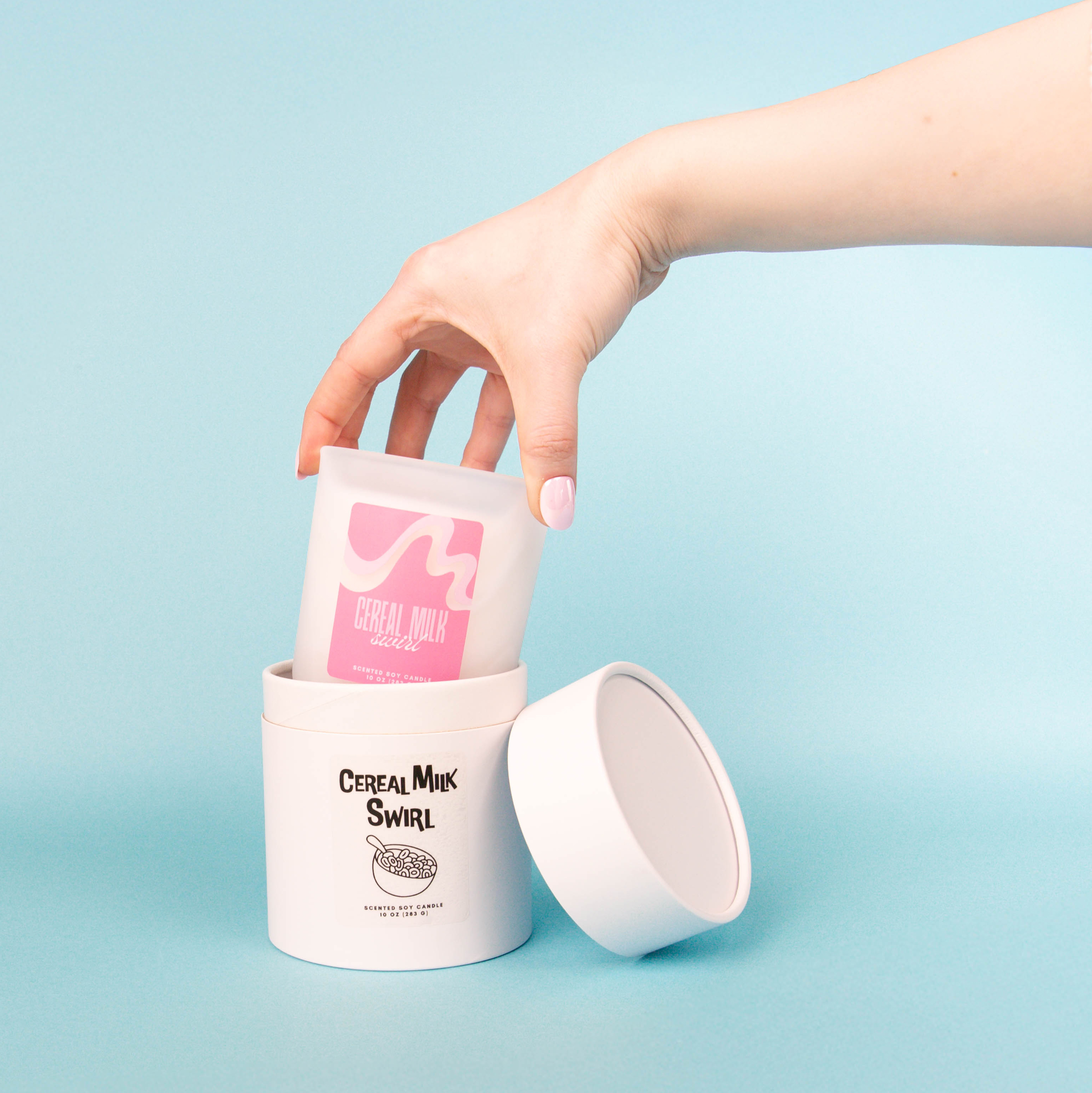 Three mini dessert themed candles with heart embeds on a pile of multi-colored candy heart wax melts