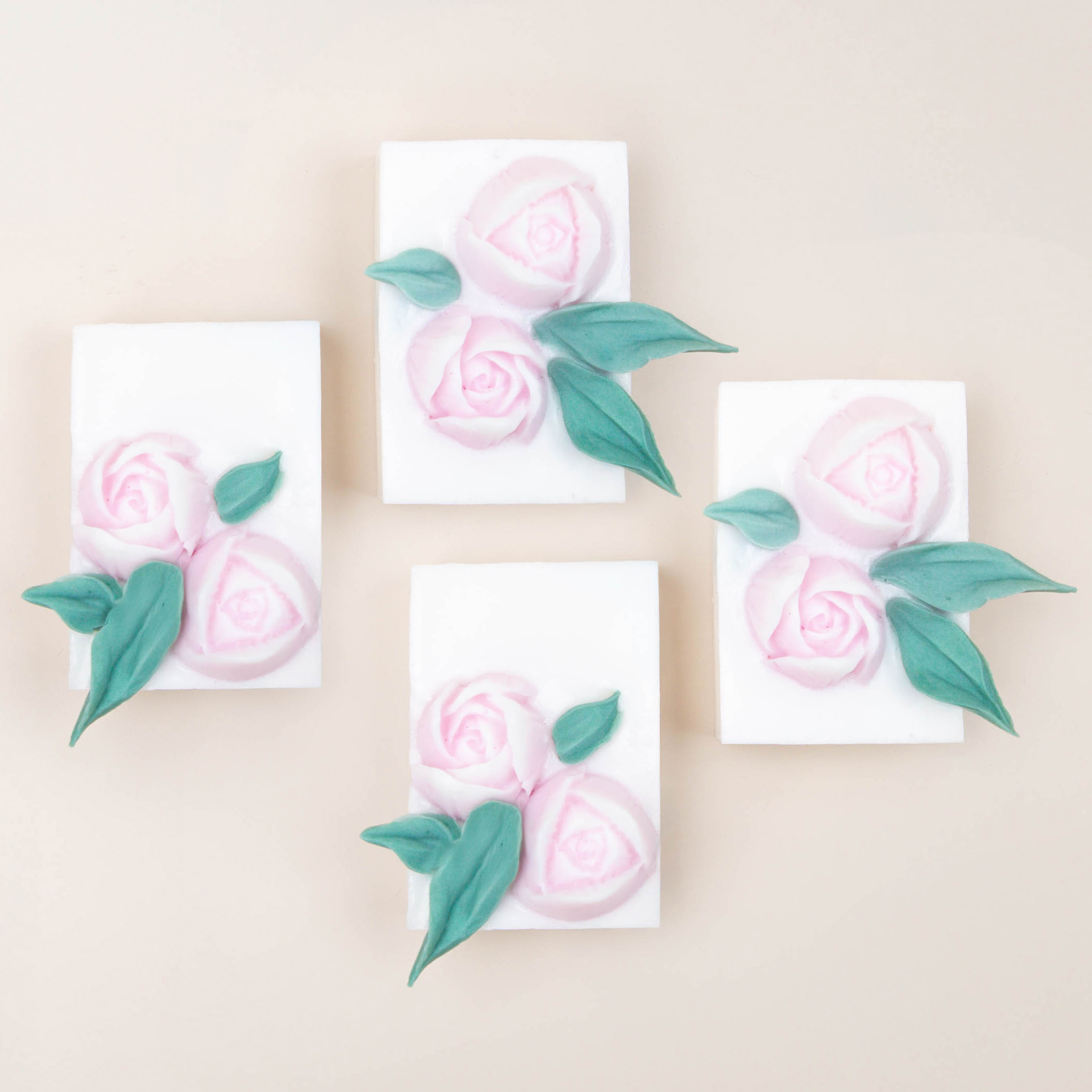 Two hands arranging bleeding heart wax melts in a white gift box