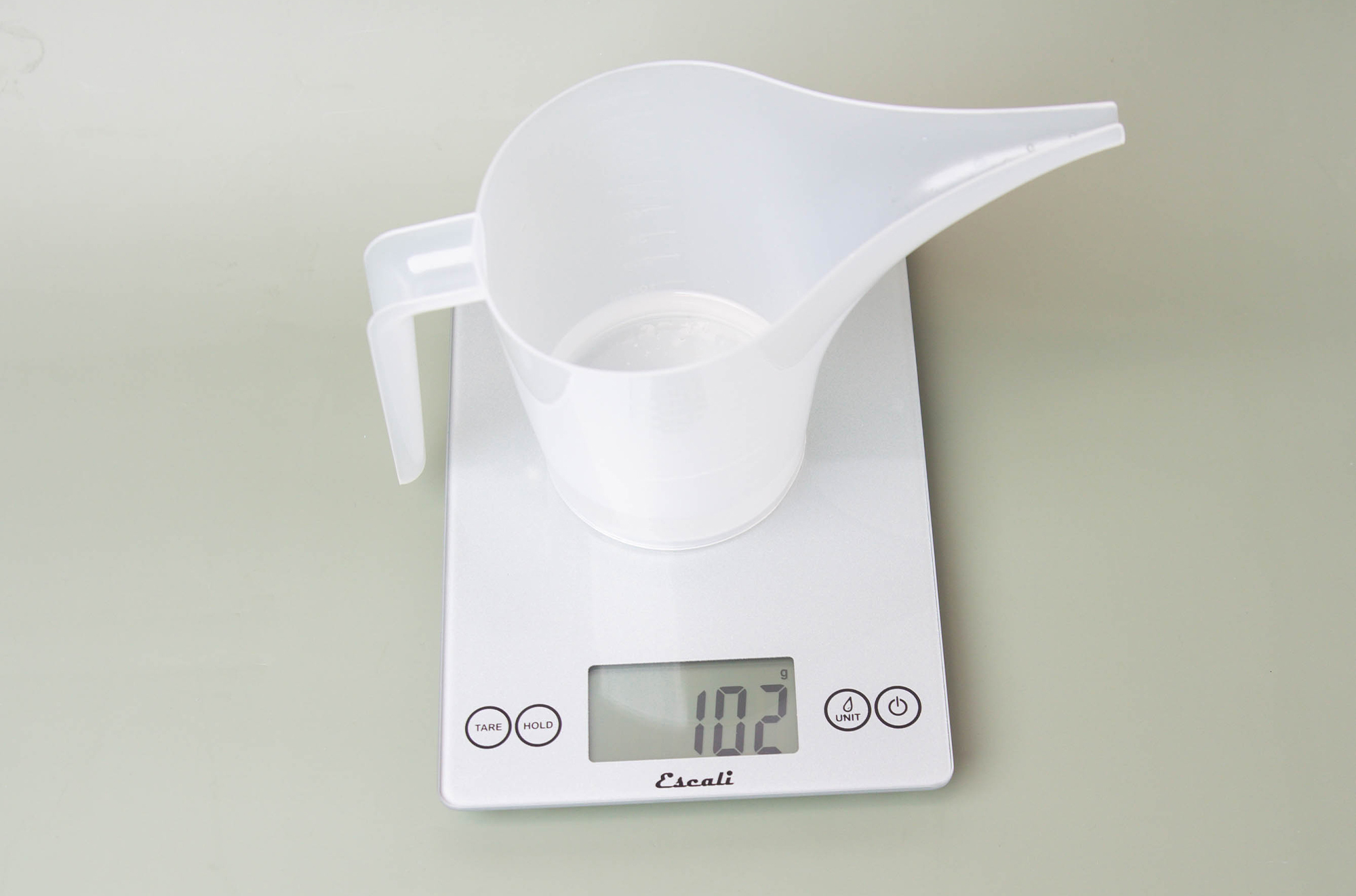 Weighing a funnel pouring pitcher on a scale.