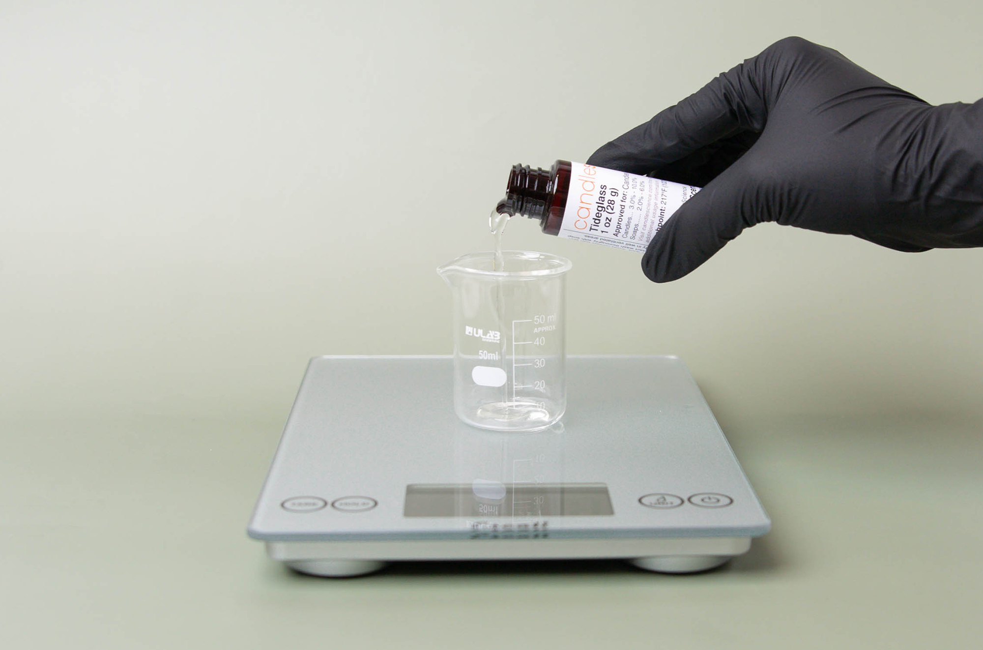 Weighing fragrance oil on a scale.