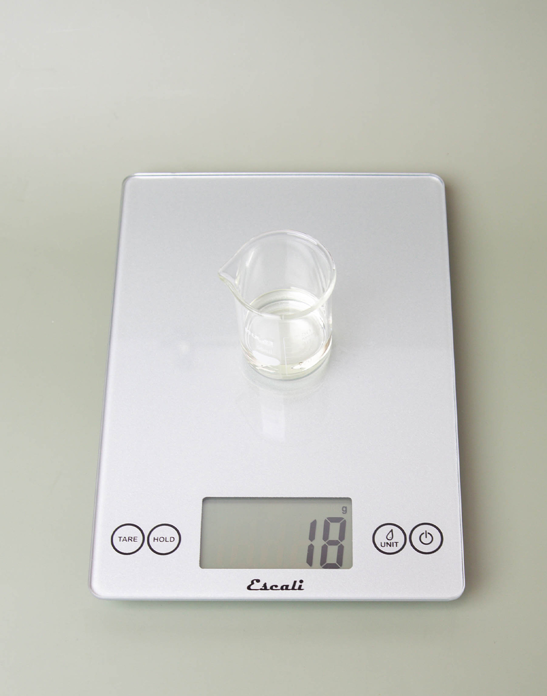 Weighing fragrance oil on a scale.