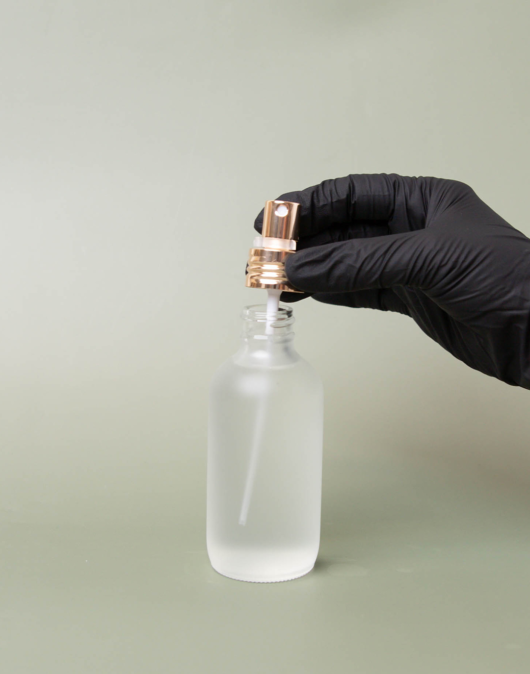 Putting pump onto perfume bottle.
