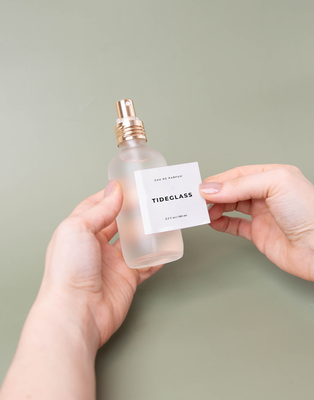 Adding a label onto glass perfume bottle.