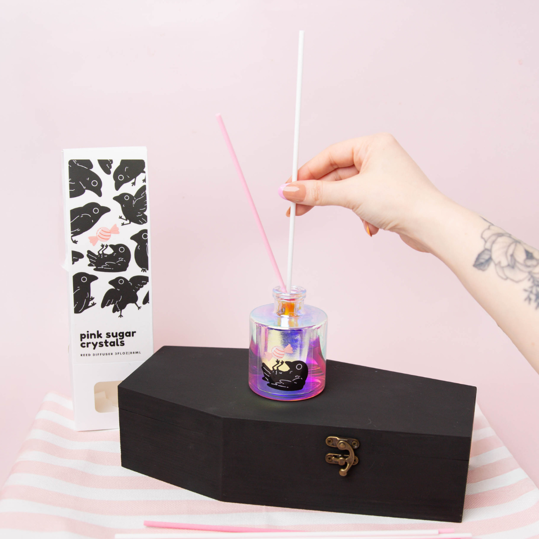 Adding pink, light pink, and white reed diffuser sticks to a reed diffuser bottle.