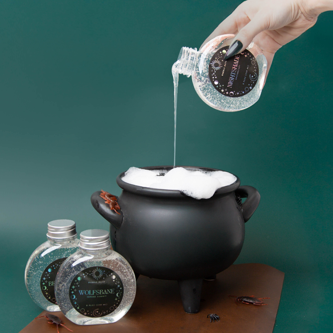 Pouring Halloween themed bubble bath into a bubbly cauldron.