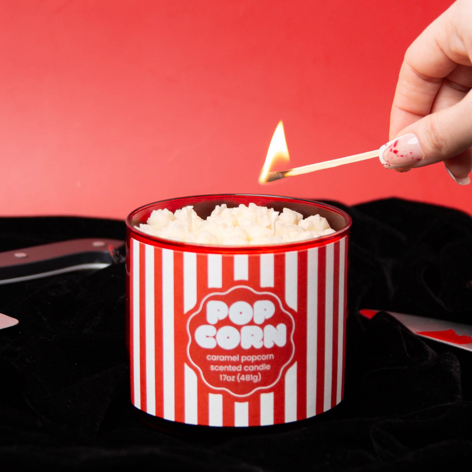 A hand lighting a popcorn candle.
