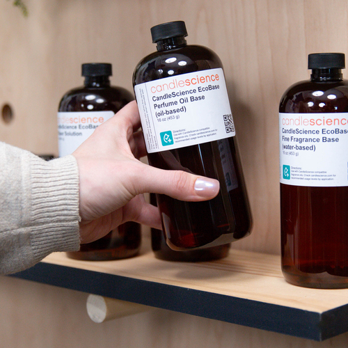 Hand grabbing an EcoBase from a wooden shelf.
