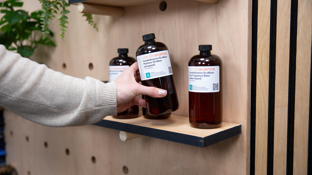 A hand grabbing a CandleScience EcoBase from a shelf.