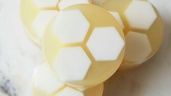 Honeycomb facial soaps stacked on a marble countertop.