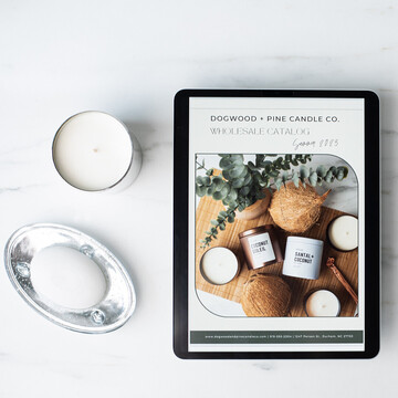 An iPad screen displays the front cover of a wholesale line sheet for Dogwood + Pine Candle Co.