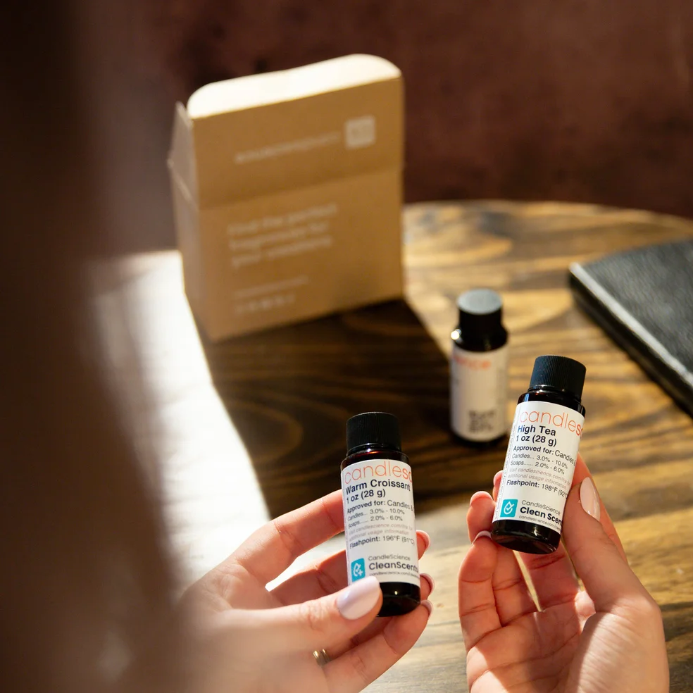 Hands holding 1 oz fragrance oil bottles from a fragrance flight.